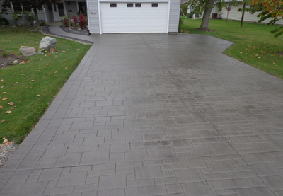 Stained and polished concrete driveway, stamped to look like pavers.