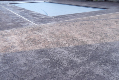 Gray stained pool deck around in ground pool.
