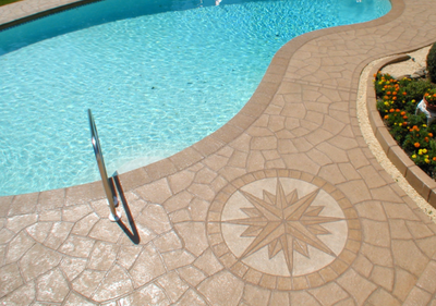 Decorative pool deck with compass design stamped into the concrete.