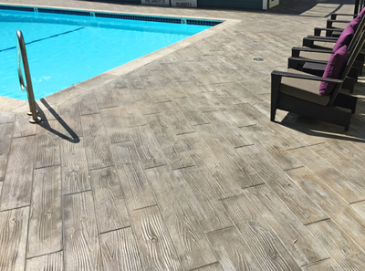 Wood grain plank design stamped into concrete pool deck.