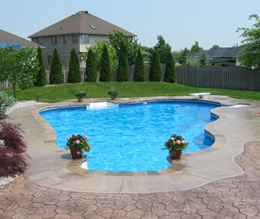 Concrete pool deck with plain concrete around the border and stamped concrete around that.