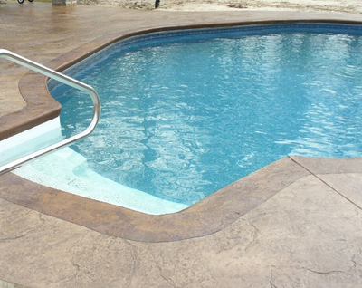 Indoor pool with a textured and stained concrete pool deck.