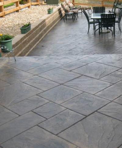 Tile shaped stamped concrete patio with steps to porch.